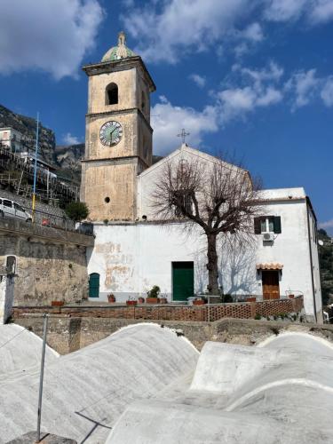 une église avec une tour d'horloge dans un bâtiment dans l'établissement Villa Amalfi, à Amalfi
