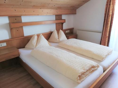 a bedroom with two beds with white blankets and pillows at Aclavaldafur Apart in Nauders