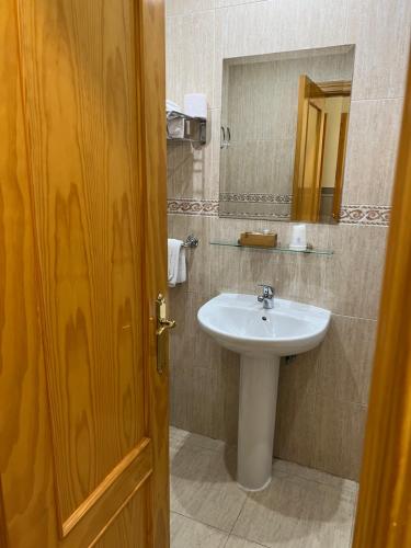 a bathroom with a sink and a mirror at Hostal 82 in Olías del Rey