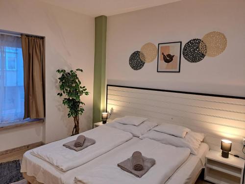 a bedroom with a large white bed with towels on it at Luna Apartman in Eger