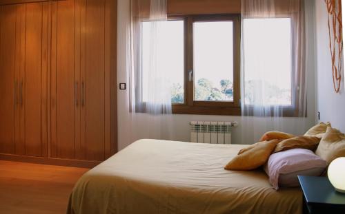 a bedroom with a large bed with two windows at La Jarocha, casa con vistas al mar en Pechón in Pechón