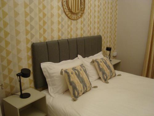 a bed with a green headboard and two pillows at Gallery Hotel in Amman