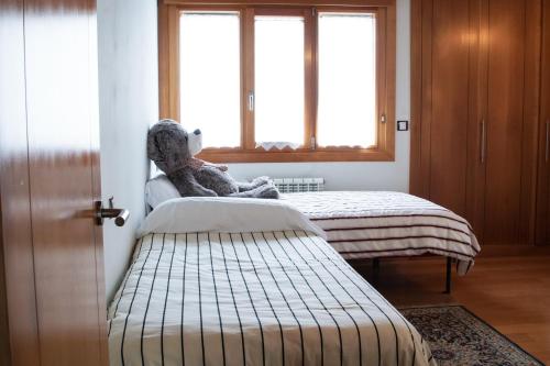 a teddy bear sitting on a bed in a room at La Jarocha, casa con vistas al mar en Pechón in Pechón