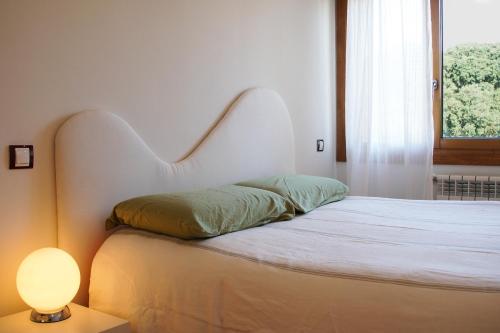 a bed with a white headboard next to a window at La Jarocha, casa con vistas al mar en Pechón in Pechón