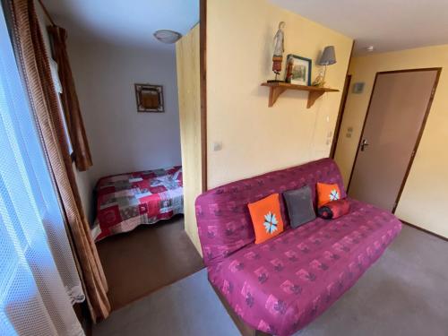 een woonkamer met een roze bank en een bed bij Studio Abondance, 1 pièce, 4 personnes - FR-1-692-55 in Abondance