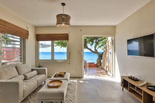 a living room with a couch and a view of the ocean at Hamaka condo a beachfront retreat on Simpson Bay Beach in Simpson Bay