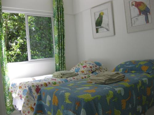 a bedroom with a bed and a window at Porto Real Suites in Mangaratiba