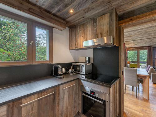 une cuisine avec des armoires en bois et un four à plaques de cuisson dans l'établissement Appartement chaleureux proche pistes de ski et golf à Megève - FR-1-569-67, à Megève