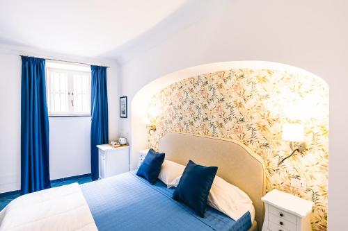 una camera da letto con un grande letto con cuscini blu di Al Borgo Torello a Ravello