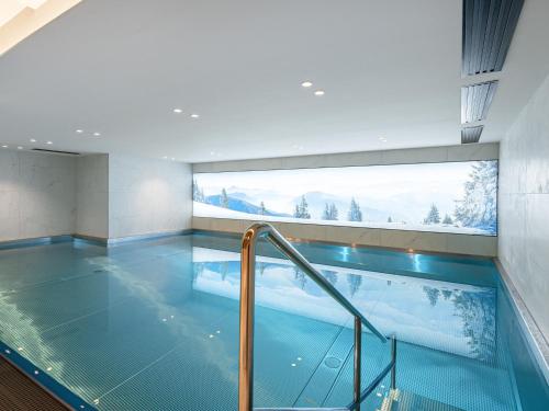 une piscine dans un immeuble avec une grande fenêtre dans l'établissement Chalet à Megève avec Wellness: 6 adultes, 4 enfants, ascenseur, terrasse, cheminée, accès sauna/piscine - FR-1-569-56, à Megève
