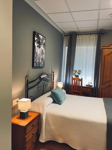 a bedroom with two beds and a table and a window at Hostal Paulino in Trujillo