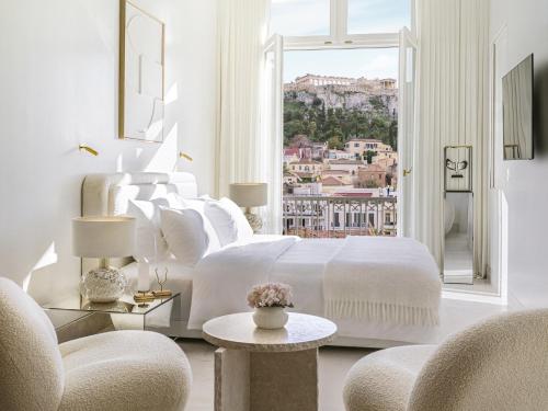 a white bedroom with a bed and a large window at The Dolli at Acropolis, A Hotel to Live in Athens