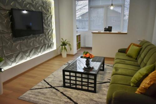 a living room with a green couch and a coffee table at Confort Apartament in Ploieşti