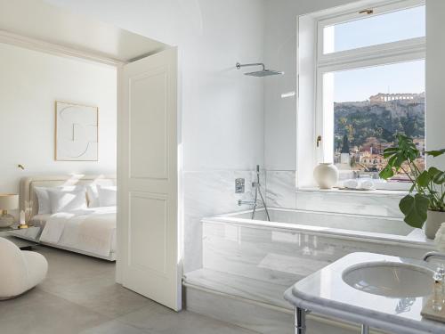 a white bathroom with a bed and a window at The Dolli at Acropolis, A Hotel to Live in Athens