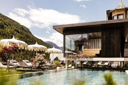 a resort with a pool in front of a building at Alpin Garden Luxury Maison & SPA - Adults Only in Ortisei