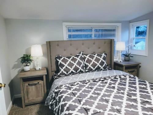 een slaapkamer met een bed en twee nachtkastjes met lampen bij No Chores, house with private parking, yard in West Seneca