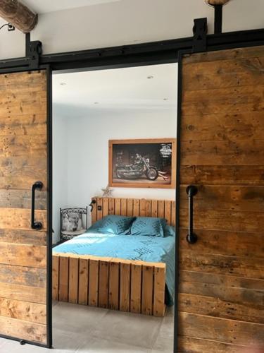 - une chambre avec un lit à l'intérieur d'une porte en verre dans l'établissement MAS DE VILLE AVEC PISCINE DANS SON COCON DE VERDURE - ESPRIT INDUSTRIEL, à Carpentras