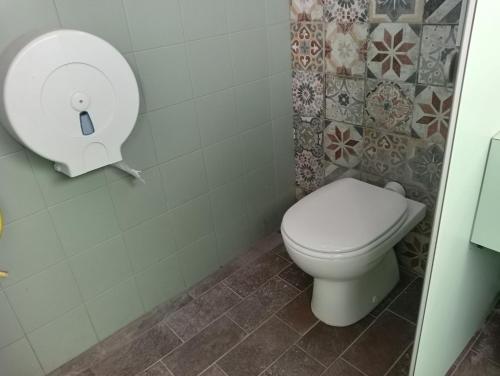 a bathroom with a toilet with a paper dispenser on the wall at Agricampeggio Oro Verde in Verona