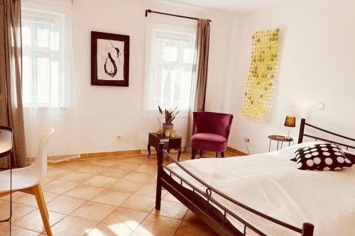 a bedroom with a bed and a table and chairs at Künstler Ferienwohnung am Weilburger Schloss, Marktplatz 9 in Weilburg