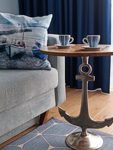 a coffee table with two cups on top of a couch at Zalotna Mewa Gąski in Gąski