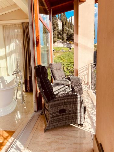 two chairs and a bath tub on a balcony at Relais Colle San Pietro in Verona