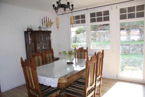 a dining room with a table and chairs and windows at Dom na Warmii in Lidzbark Warmiński