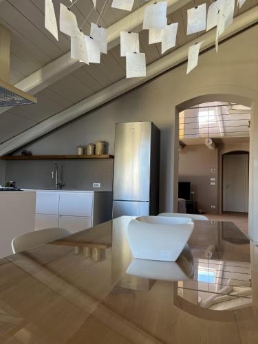 a kitchen with a glass table and a refrigerator at Luxury Langhe Loft in La Morra
