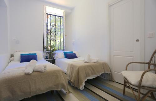 Cette chambre blanche dispose de 2 lits et d'une fenêtre. dans l'établissement VILLA CLAVERO ONE Premium Apt, à Malaga