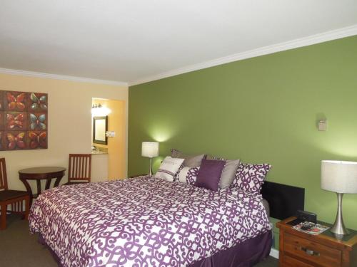 a bedroom with a bed and a green wall at Tea Garden Lodge in South Lake Tahoe