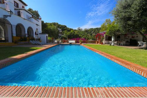 een zwembad met blauw water in een tuin bij VILLA CLAVERO TWO Premium Apt in Málaga