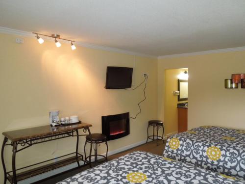 a hotel room with a bed and a fireplace at Tea Garden Lodge in South Lake Tahoe