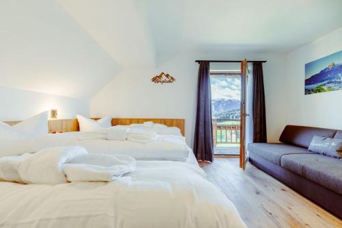 a bedroom with two white beds and a couch at Das Salzburgblick in Ainring