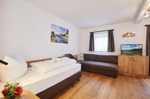 a living room with a bed and a couch at Das Salzburgblick in Ainring