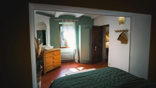 a bedroom with a bed and a dresser and a mirror at Le Mas Fraissinet in Saint-Jean-de-Valériscle