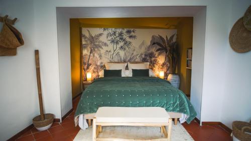 a bedroom with a green bed with two white chairs at Le Mas Fraissinet in Saint-Jean-de-Valériscle