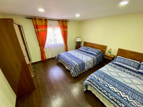 a bedroom with two beds and a window at Alojamiento RBOY Las Mariposas in Chillán