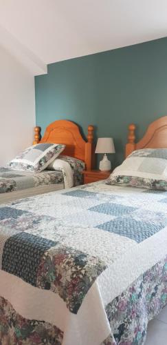 2 letti singoli in una camera da letto con pareti blu di Emilia Atico a Lariño