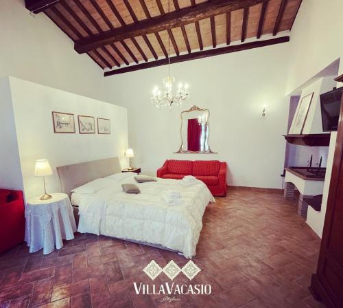 a bedroom with a white bed and a red couch at Agriturismo Eco-Bio Villa Vacasio in Pitigliano