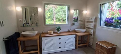een badkamer met 2 wastafels en 2 spiegels bij Magnifique villa 5 etoiles avec piscine privee parc 2 ha in La Limouzinière