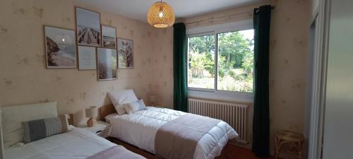 een slaapkamer met 2 bedden en een raam bij Magnifique villa 5 etoiles avec piscine privee parc 2 ha in La Limouzinière