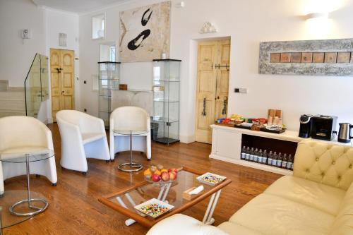 ein Wohnzimmer mit weißen Stühlen und einem Tisch in der Unterkunft Avanguardia Art Club in Ferrara