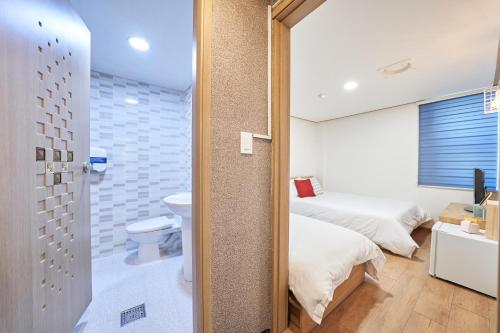 a bathroom with a bed and a toilet in a room at K'STAY Sinchon in Seoul