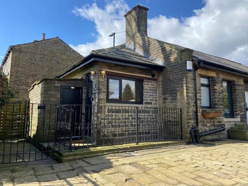 a brick house with a fence in front of it at Unique Victorian stable conversion Halifax in Halifax