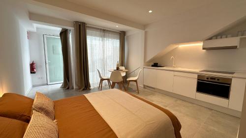 a bedroom with a bed and a kitchen with a table at ART HOMES LAVADERO in Valencia