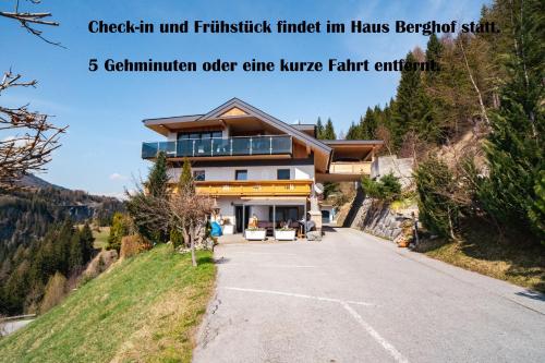 une maison sur une colline avec les mots enregistrement et finition dans son arrière-cour dans l'établissement Steinhof, à Gries am Brenner