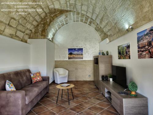 a living room with a couch and a tv at Il Giardino Sulla Valle in Ragusa