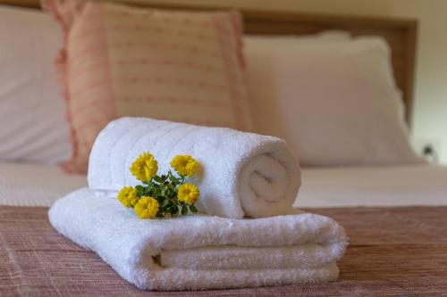 a towel with flowers on it on a bed at Avocado Villa Iason in Chania Town