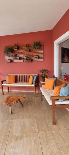 a living room with benches and a red wall at Pousada Litorânea in São Luís