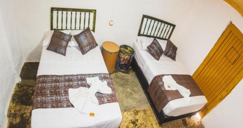 2 camas individuales en una habitación en Hostel Tatacoa, en Villavieja
