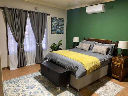 ein Schlafzimmer mit einem Bett und einer grünen Wand in der Unterkunft at 22 Symmonds in Melmoth